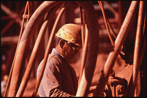 Man in construction hat working on pipes